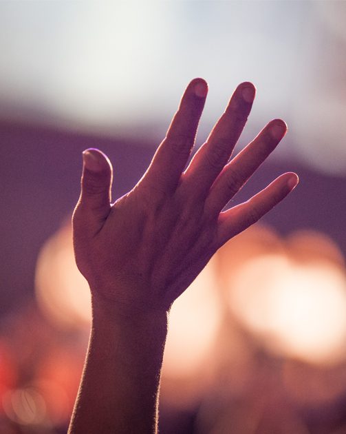 close up of hand extended towards the ceiling