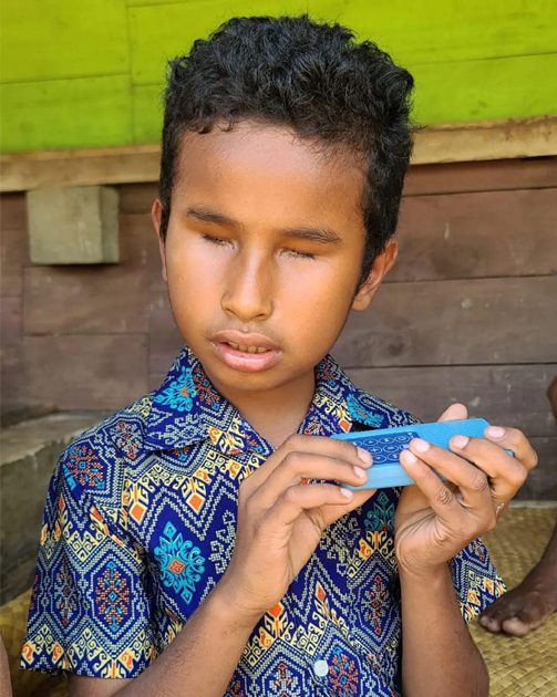 a young, visually impaired boy using a Leading The Way audio recorder