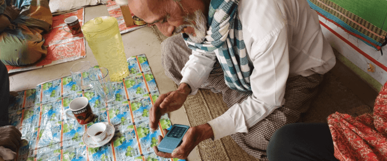 A man sits on a floor, holding a radio