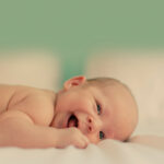 Infant lying on the bed happy and smiling
