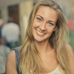 Single adult woman smiling with head tilted