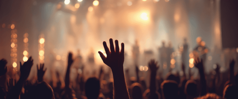 A crowd facing the stage with their hands up