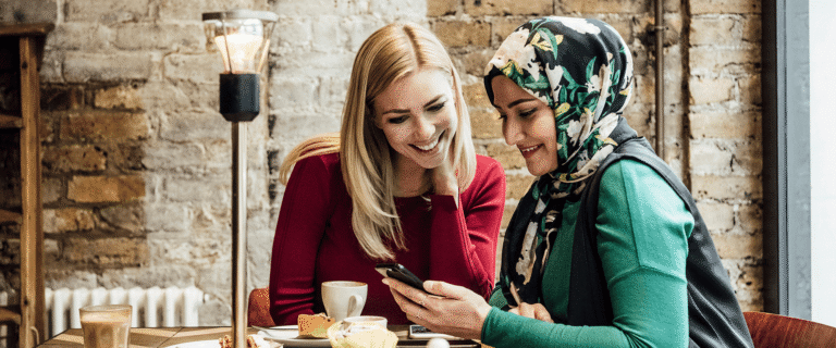 A Christian woman and Muslim woman are talking at a table