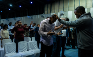 Man in a church being prayed over while during worship service