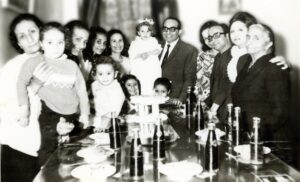 Old black and white image of a family gathered around a table