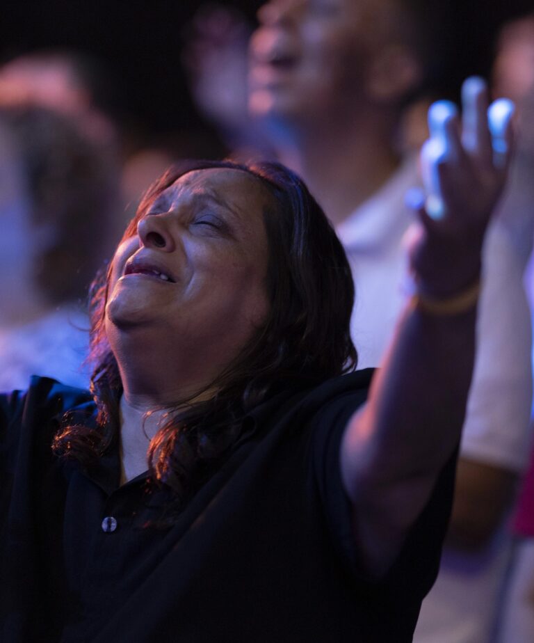 Egyptian woman worshipping with her arms lifted high and eyes closed