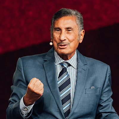 DMY making a speech wearing a gray suit